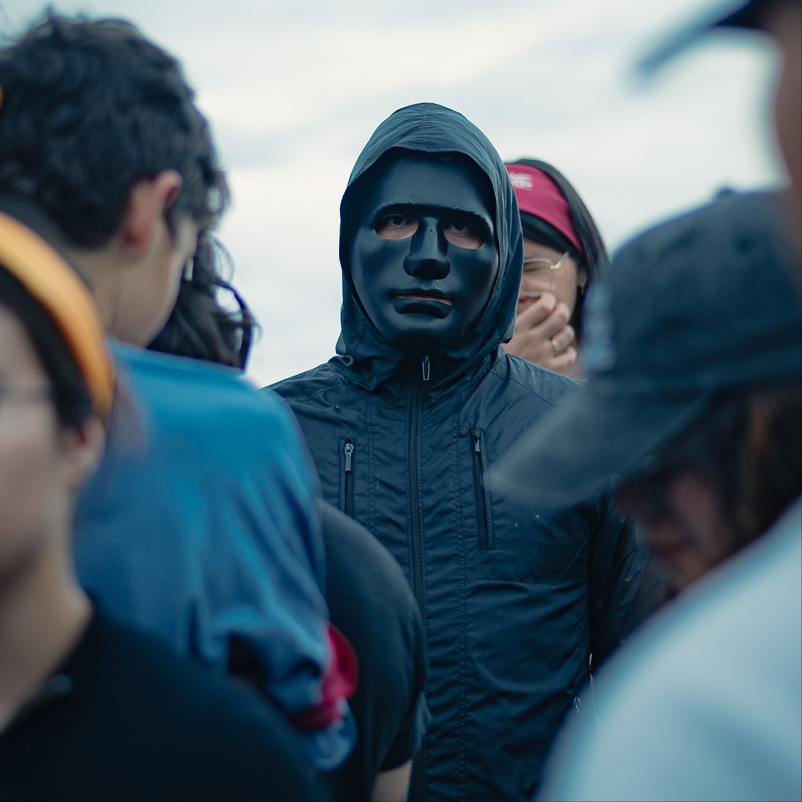 Campista con máscara entre la multitud