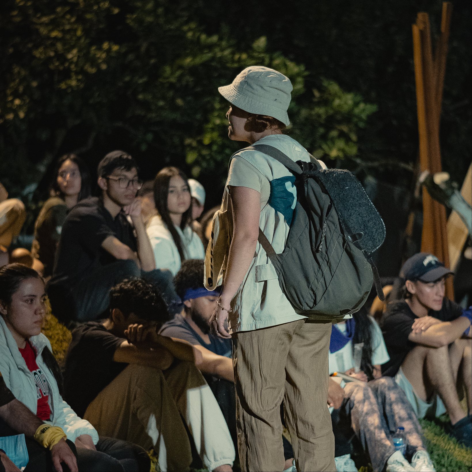 Jóvenes reunidos de noche en el campamento
