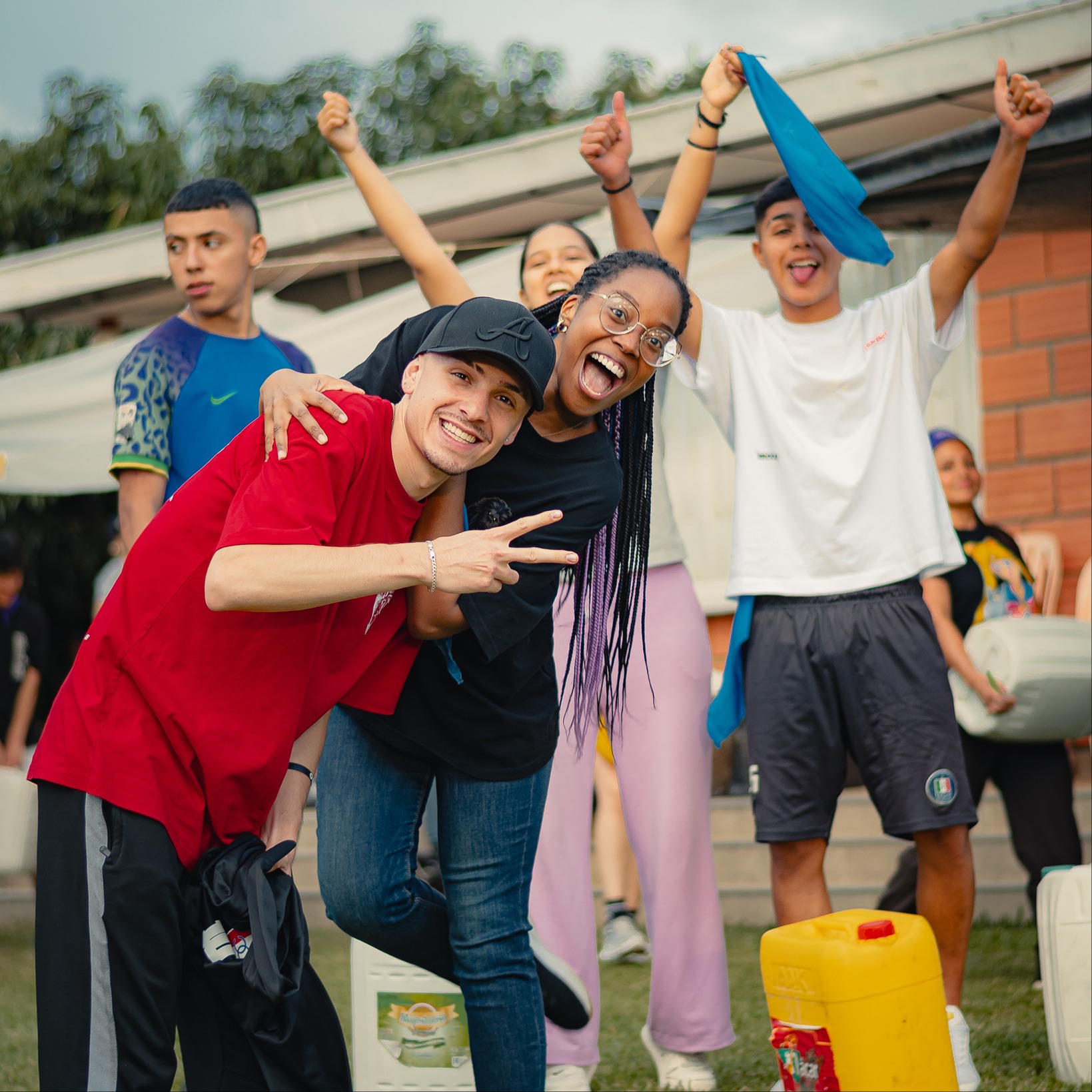 Grupo de jóvenes celebrando al aire libre en el campamento